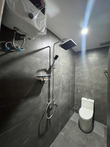 a bathroom with a toilet and a light on the wall at Dana Home MT in Danang
