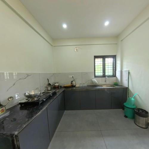 a large kitchen with a counter and a sink at Philip's Signature Suites in Cochin