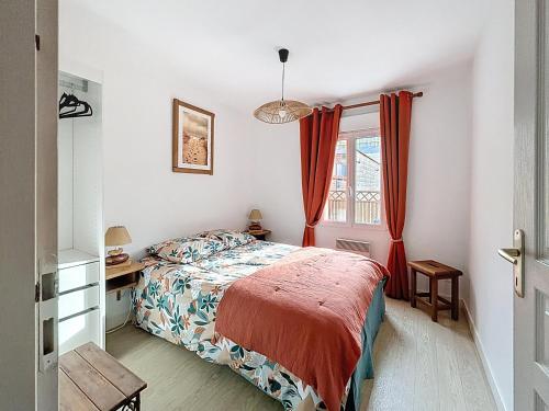 Un dormitorio con una cama y un escritorio y una ventana. en Maison des dunes, en Fort-Mahon-Plage
