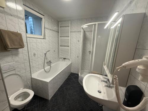 a bathroom with a sink and a toilet and a bath tub at Groß Genuss in Kaibing