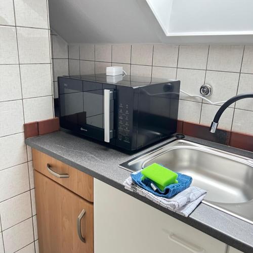 a microwave sitting on a kitchen counter next to a sink at Red Dot Apartment Bruno in Werne an der Lippe