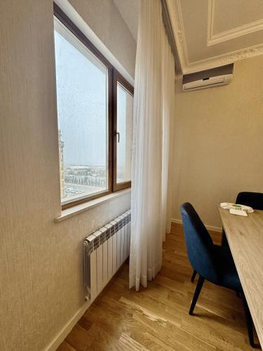 a room with a desk and a window and a chair at Sumgayit Apart House in Sumqayıt