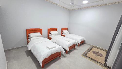 a group of four beds in a room at Suhail Star Guest House in Misfāh