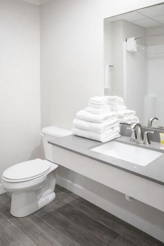 a white bathroom with a toilet and a sink at Islander Inn in Put-in-Bay