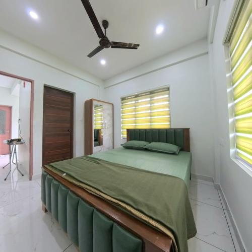 a bedroom with a bed and a ceiling fan at Philip's Signature Suites in Cochin