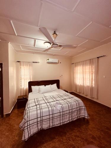 a bedroom with a bed and a ceiling fan at C&B House MV in Accra