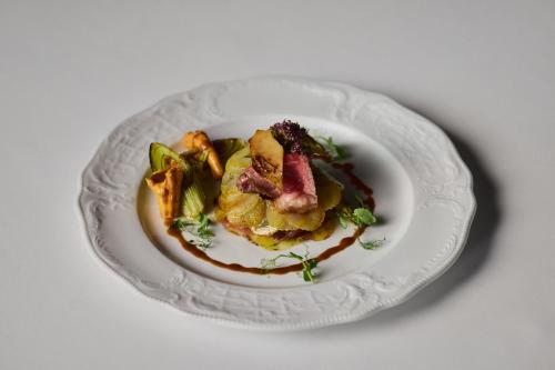 a plate of food on a white plate at Hotel Sassongher - Preferred Hotels & Resorts in Corvara in Badia