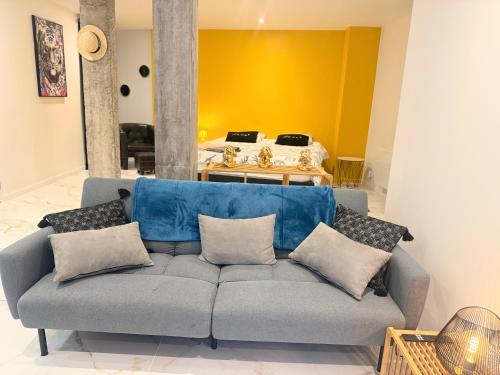a living room with a couch with pillows at Magnifique studio, proche du centre in Rodez