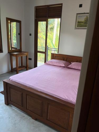 a bedroom with a large bed with a purple mattress at Gurugoda Riverside Villa in Ruwanwella