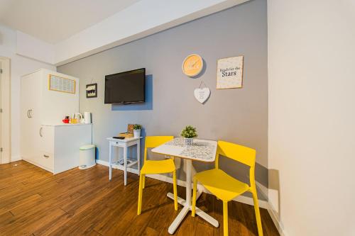 a dining room with a table and yellow chairs at Flex SelfCheckIns 209 - Zagreb - Studio Apartment - Centre in Zagreb