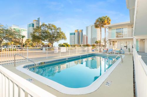 a swimming pool at a apartment complex with buildings at Fin's Inn & Suites in Myrtle Beach