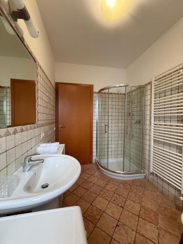 a bathroom with a tub and a sink and a shower at ZIO CESARE FOSSO' 4 int 2 in Fossò