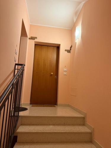 a hallway with a wooden door and stairs at ZIO CESARE FOSSO' 4 int 2 in Fossò