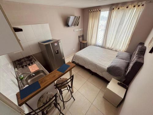 a small room with a bed and a kitchen with a sink at ApartaHotel Holguin in Estación El Salto