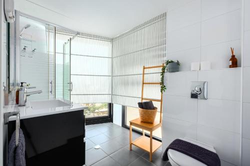 a white bathroom with a sink and a toilet at Mr Neve Tsedek in Tel Aviv