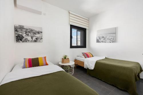 a bedroom with two beds and a window at Mr Neve Tsedek in Tel Aviv