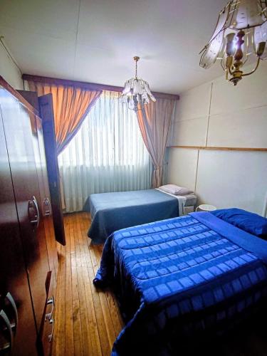 a bedroom with two beds and a chandelier at Central House in Punta Arenas