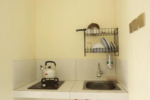 a small kitchen with a sink and a tea kettle at Diiza Glamping Tawangmangu Private Pool No BBQ in Tawangmangu