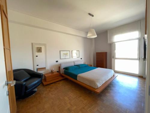 a bedroom with a bed and a chair in it at Charming beach front apartment in Viareggio