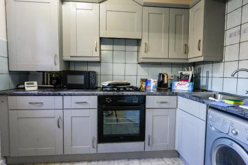 a kitchen with white cabinets and a dishwasher at Burnvale Apartment in Livingston
