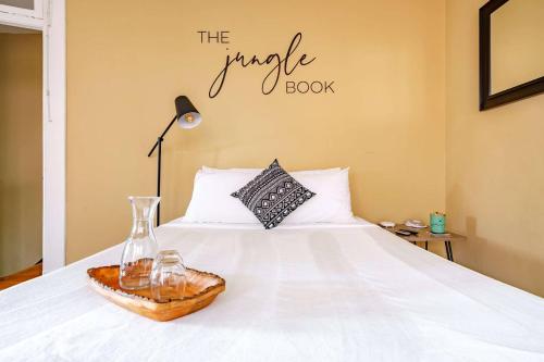 a bedroom with a white bed with a vase and a book at The Parkside by Jungle House - Short North Boutique Suites in Columbus