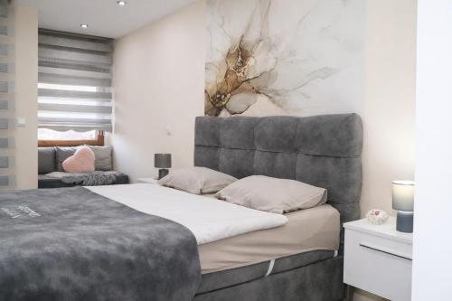 a bedroom with a large bed and a couch at Apartman Jaman - Novi Pazar in Novi Pazar