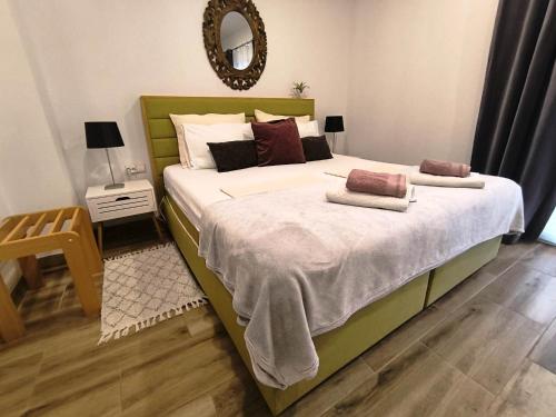 a bedroom with a large bed with two pillows on it at Wellness Apartments Ra in Primošten