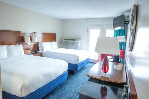 a hotel room with two beds and a table with a lamp at Islander Inn in Put-in-Bay