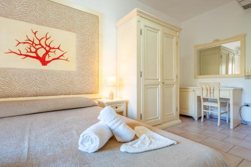 a bedroom with a bed with a towel on it at A.I.R. Hotel Gabbiano in Isola Rossa
