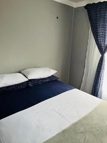 a bed with two pillows and a window in a room at Kasi Retreat in Northam