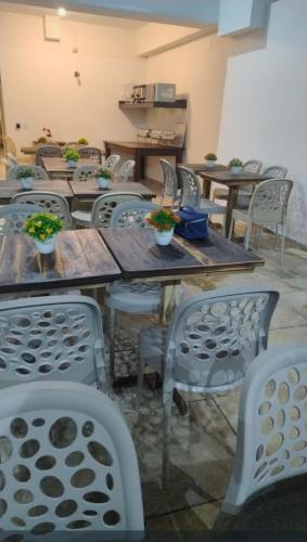 a group of tables and chairs with potted plants on them at Pousada Pérola dos Corais Maceió in Maceió