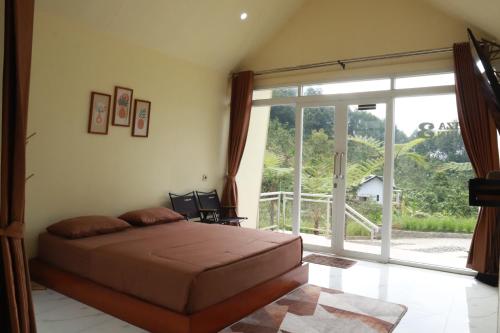a bedroom with a bed and a large sliding glass door at Diiza Glamping Tawangmangu Private Pool No BBQ in Tawangmangu
