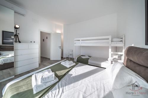 a bedroom with two bunk beds and a couch at Panorama Blu - Spiaggia 7min - Terrazza - WiFi in Celle Ligure