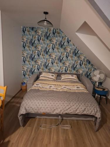 a bedroom with a large bed with a blue wall at Studio l'écluse in Le Tréport