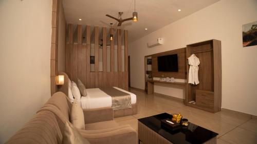 a bedroom with a bed and a couch in a room at Corbett Elegant Retreat Jim Corbett in Rāmnagar