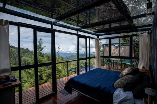 a bedroom with a bed in a room with windows at Kamarí Glamping in San Francisco