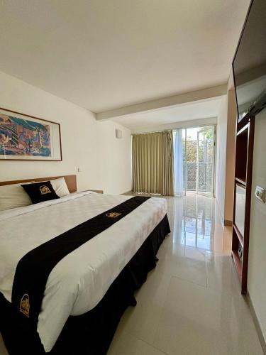ein Hotelzimmer mit einem großen Bett und einem Fenster in der Unterkunft Concordia Hotel Bumi Sangkuriang Bandung in Bandung