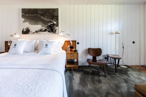a bedroom with a white bed and a chair at Casa do Rio - Douro Wine Hotel by Vallado in Vila Nova de Foz Coa