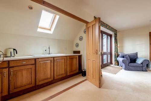 a kitchen with a sink and a window and a chair at Melon Park - Elie in Elie