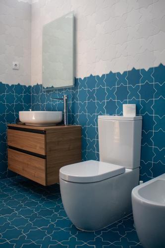 a blue bathroom with a toilet and a sink at Quinta das Candeias - Casa da Bé in Arcos de Valdevez