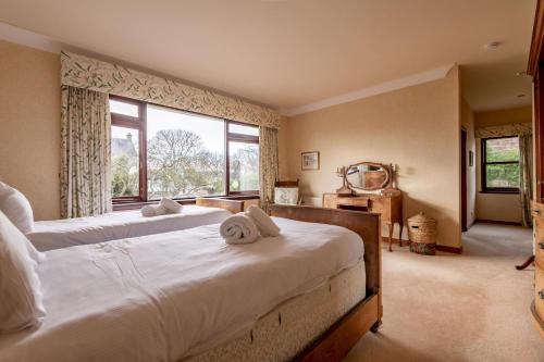 a bedroom with two beds and a large window at Melon Park - Elie in Elie