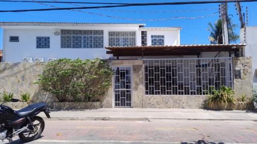 a motorcycle parked in front of a house at Pousada Pérola dos Corais Maceió in Maceió