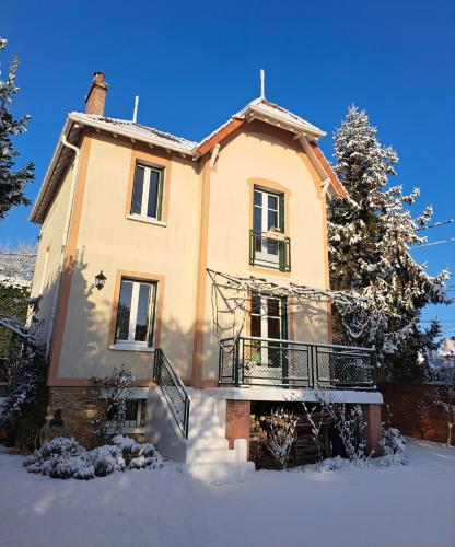 an old house with snow on the ground at la villa des chats in Andrésy