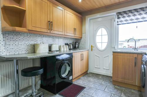 a kitchen with a washer and a washing machine at Jake's House in Airdrie