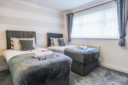 a bedroom with two beds and a window at Jake's House in Airdrie