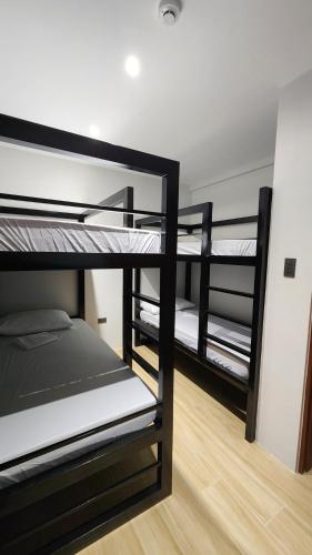 a room with three bunk beds in a room at Solunara Malolos in Malolos