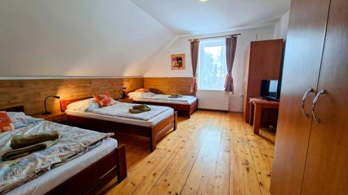 a hotel room with two beds and a television at Penzion a restaurace Polnička in Polnička