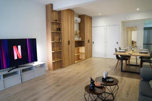 a living room with a television and a table at Casa Dolce Casa - Elegant 3BR Apartment Near Metro & Beach,Valencia in Valencia