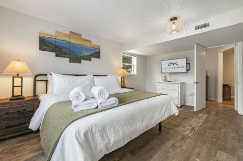 a bedroom with a large bed with towels on it at Mountain View Cottage by Carolina Mornings in Waynesville