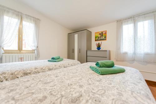 a bedroom with two beds with green pillows on them at Relax Stay vicino Padova e Brenta in Vigonza